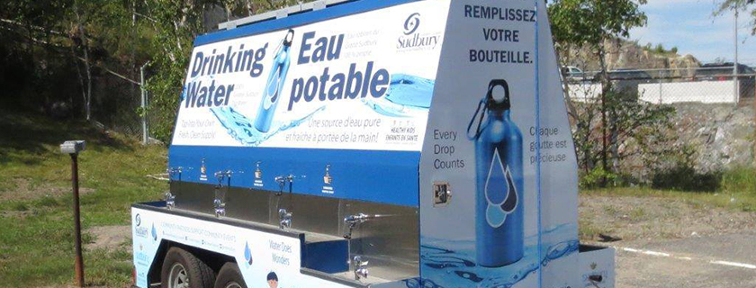 Remorque de chariot à eau avec des fontaines à eau potable sur le côté.